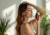 Jeune femme aux cheveux hydratés appliquant un soin capillaire