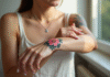 Jeune femme appliquant crème sur son bras avec tatouage floral